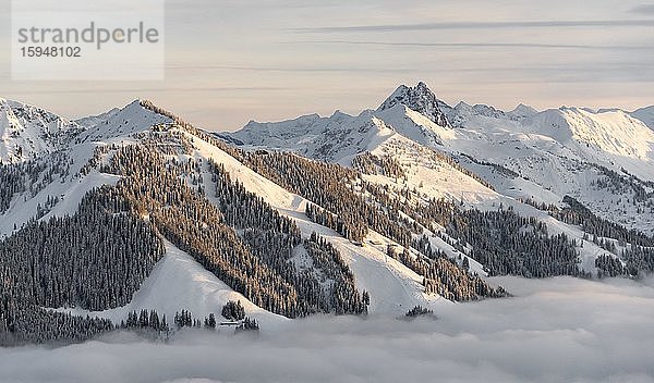 Blick auf schneebedeckte Berggipfel  Gipfel Gampenkogel und Großer Rettenstein im Abendlicht  Hochnebel im Tal  Hochbrixen  Brixen im Thale  Tirol  Österreich  Europa