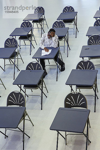 Engagierter High-School-Schüler nimmt Prüfung am Schreibtisch im Klassenzimmer ab