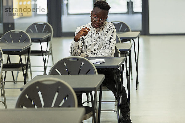 High-School-Schüler nimmt Prüfung am Schreibtisch im Klassenzimmer ab