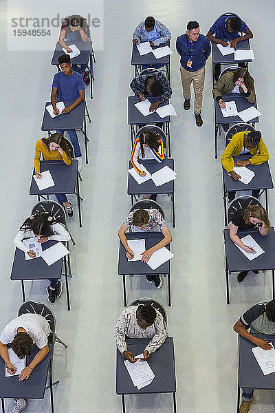 Gymnasiallehrer beaufsichtigt Schüler  die Prüfungen am Schreibtisch ablegen