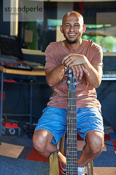 Porträt eines glücklichen Musikers mit Gitarre