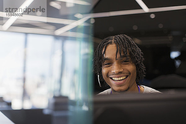 Porträt eines lächelnden Geschäftsmannes mit Headset am Computer