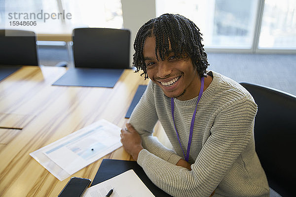 Porträt eines selbstbewussten Geschäftsmannes mit Papierkram im Konferenzraum