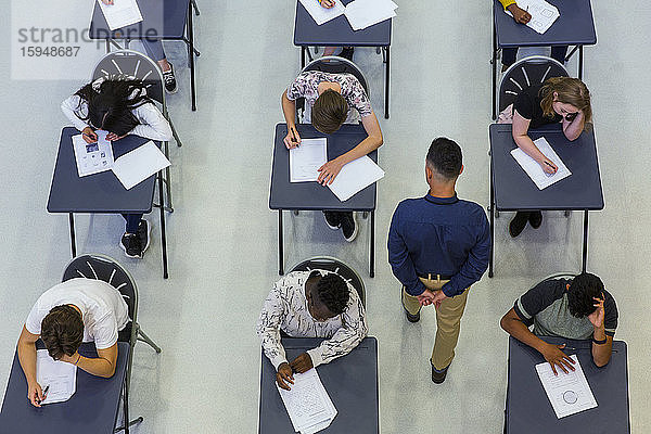 Gymnasiallehrer beaufsichtigt Schüler  die Prüfungen am Schreibtisch ablegen