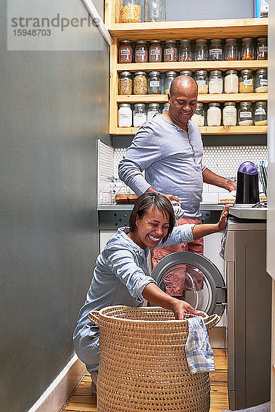 Glückliches Paar beim Wäschewaschen in der Küche