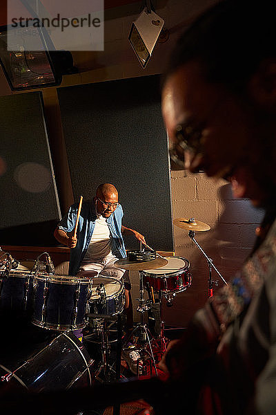 Männlicher Musiker spielt Schlagzeug im Aufnahmestudio