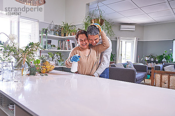 Liebevolles  reifes Paar umarmt und putzt Kücheninsel