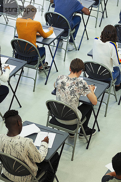 Gymnasiasten  die an Schreibtischen im Klassenzimmer Prüfungen ablegen