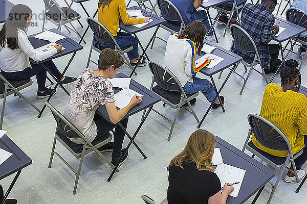 Gymnasiasten  die an Schreibtischen im Klassenzimmer Prüfungen ablegen