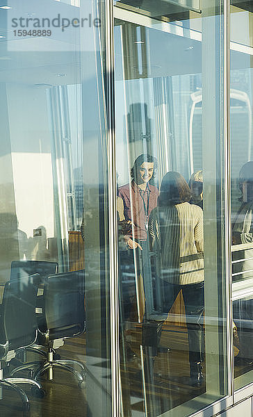 Geschäftsleute im Gespräch am sonnigen Bürofenster