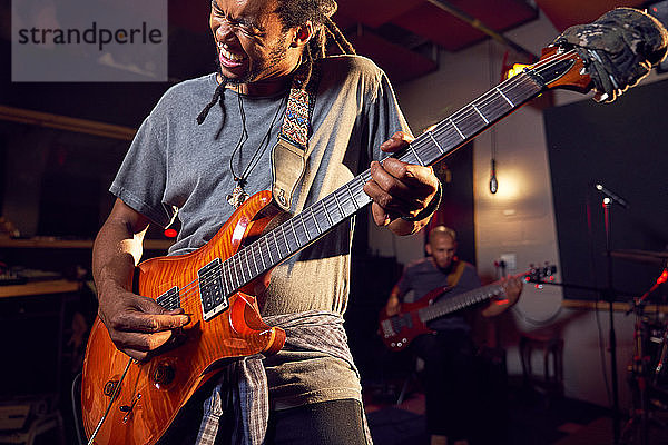 Männlicher Musiker spielt E-Gitarre im Aufnahmestudio