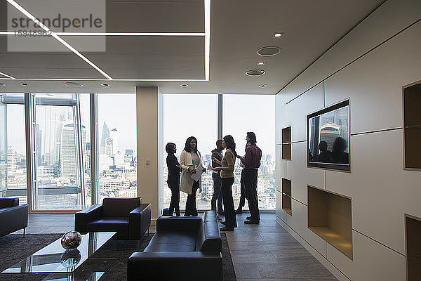 Geschäftsleute im Gespräch in moderner Hochhaus-Büro-Lobby