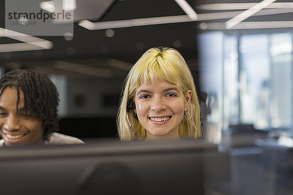 Porträt einer selbstbewusst lächelnden Geschäftsfrau mit Headset im Büro