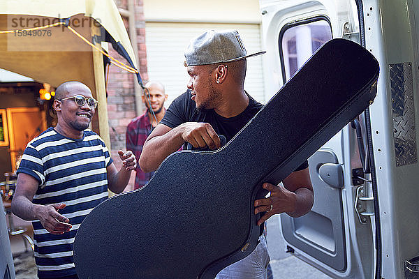 Musiker laden Gitarrenkoffer in Lieferwagen