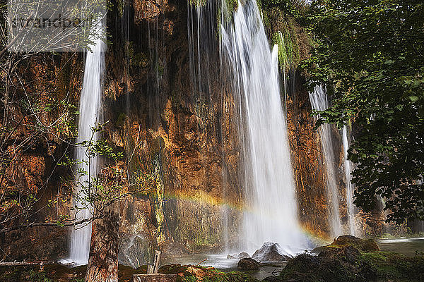 Kroatien  Kleiner Regenbogen über plätscherndem Wasserfall im Nationalpark Plitvicer Seen