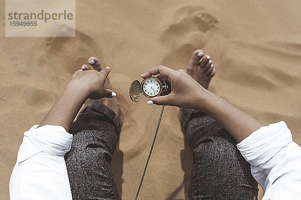 Frauenhand hält alte Taschenuhr  Wüste Merzouga  Marokko