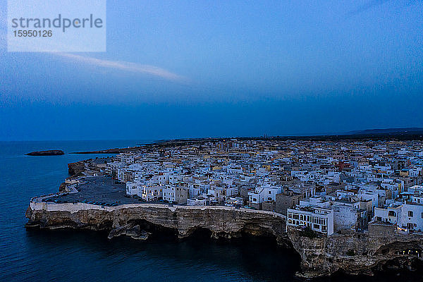 Italien  Polignano a Mare  Helikopteransicht der Klippen und Gebäude der Küstenstadt in der Abenddämmerung