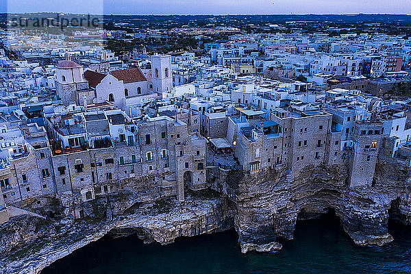 Italien  Polignano a Mare  Helikopteransicht der Klippen und Gebäude der Küstenstadt in der Abenddämmerung