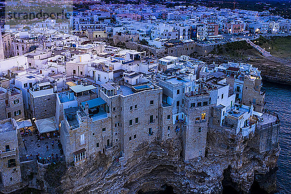 Italien  Polignano a Mare  Helikopteransicht der Klippen und Gebäude der Küstenstadt in der Abenddämmerung