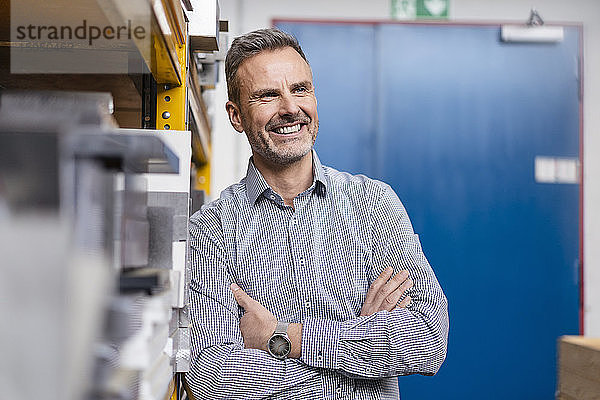 Porträt eines glücklichen Geschäftsmannes in einer Fabrik