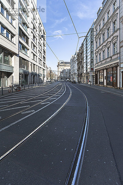 Deutschland  Berlin  Eisenbahnschienen  die sich während der COVID-19-Epidemie entlang der leeren Stadtstraße erstreckten