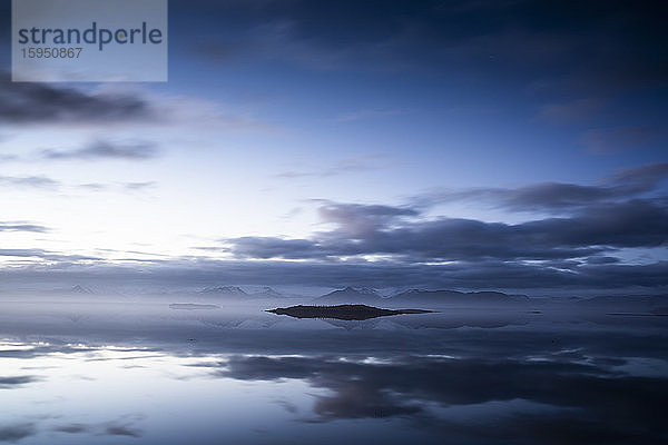 Idyllischer Blick auf die Meereslandschaft vor dramatischem Himmel in Island