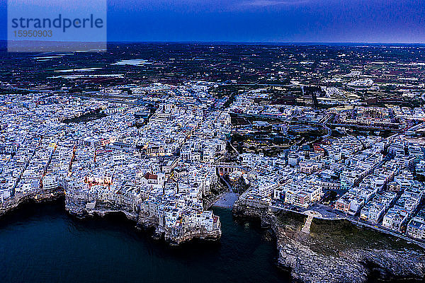 Italien  Polignano a Mare  Helikopteransicht der Klippen und Gebäude der Küstenstadt in der Abenddämmerung