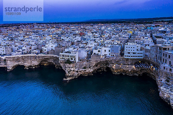 Italien  Polignano a Mare  Helikopteransicht der Klippen und Gebäude der Küstenstadt in der Abenddämmerung