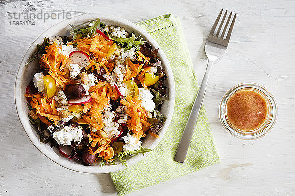 Schale mit vegetarischem Salat mit Ziegenkäse  Gerste  Radieschen  Oliven  Karotten  Tomaten und Feigen