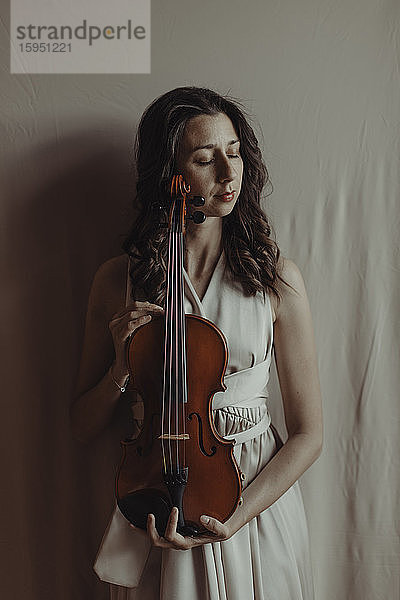 Frau mit geschlossenen Augen hält Geige