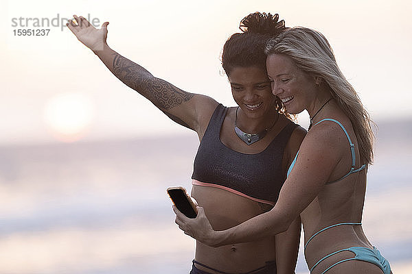 Zwei glückliche Frauen bei Sonnenuntergang am Strand  Costa Rica