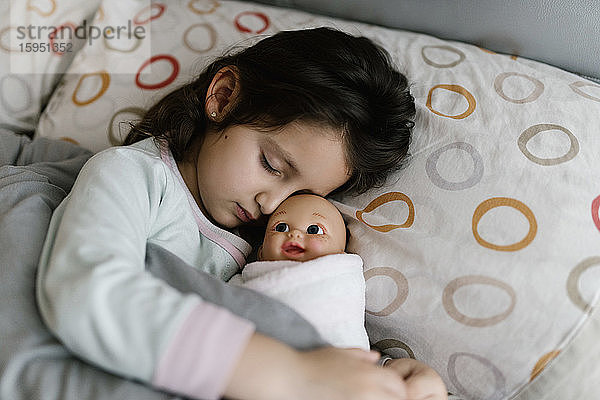 Schlafende kleine Mädchen mit ihrer Puppe