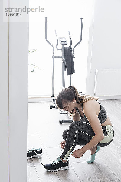 Frau bereitet sich zu Hause auf ein Workout vor
