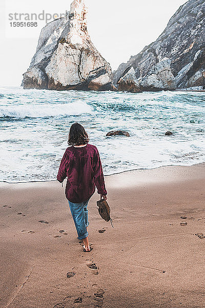 Rückansicht einer jungen Frau beim Spaziergang am Praia da Ursa  Lissabon  Portugal