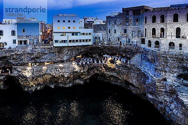 Italien  Polignano a Mare  Helikopteransicht der Klippen und Gebäude der Küstenstadt in der Abenddämmerung