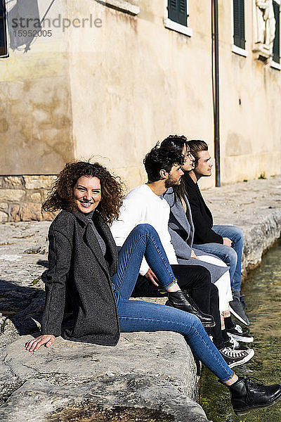Porträt von vier Freunden  die sich am Gardasee ausruhen  Italien