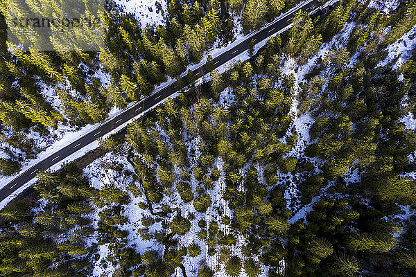 Deutschland  Bayern  Ramsau bei Berchtesgaden  Hubschrauberansicht einer leeren Autobahn  die durch schneebedeckten Bergwald schneidet