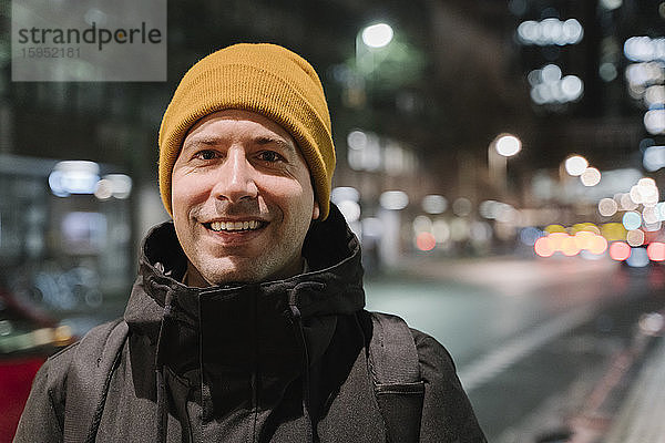Porträt eines lächelnden Mannes in der Stadt bei Nacht  Frankfurt  Deutschland