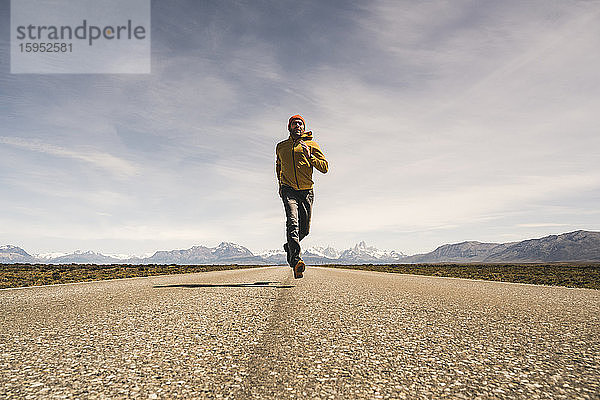 Mann rennt auf einer Straße in einer abgelegenen Landschaft in Patagonien  Argentinien
