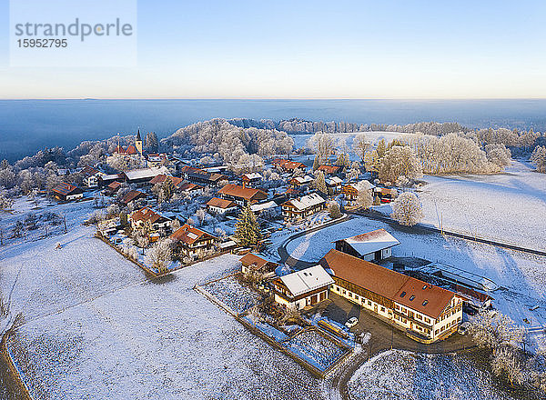 Deutschland  Bayern  Hechenberg  Drohnenansicht eines schneebedeckten Dorfes in der Nebeldämmerung