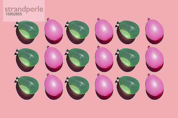 Studioaufnahme von Reihen rosa und grüner Wasserballons