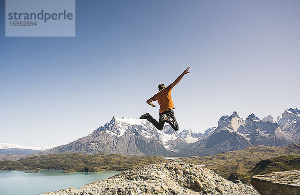 Wanderer springt in der Berglandschaft am Lago Pehoe im Torres del Paine Nationalpark  Patagonien  Chile