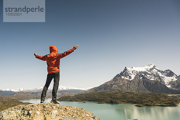 Wanderer hebt seine Arme in der Berglandschaft am Lago Pehoe im Torres del Paine Nationalpark  Patagonien  Chile