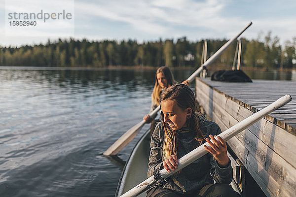 Zwei junge Frauen beim Bootfahren auf dem See