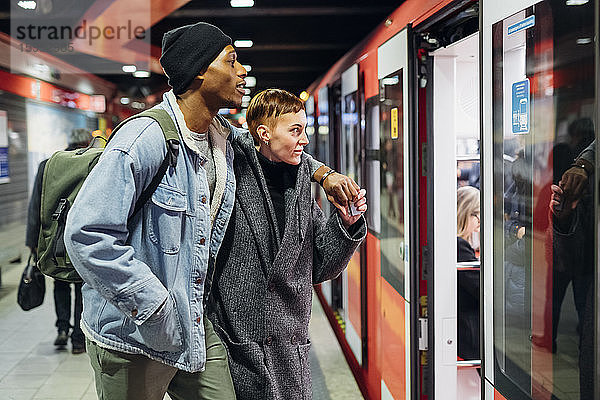 Junges Paar am Bahnsteig beim Betreten der U-Bahn