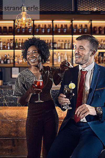 Fröhliches Paar beim geselligen Beisammensein in einer Bar