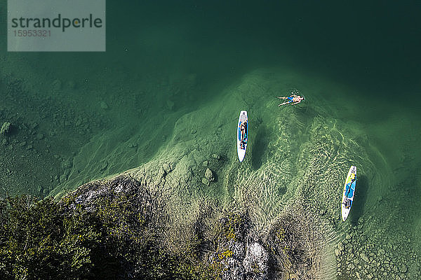 Deutschland  Bayern  Luftaufnahme von zwei Paddelboardern  die sich am grünen Ufer des Walchensees entspannen