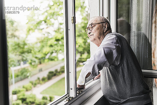 Älterer Mann schaut aus dem Fenster