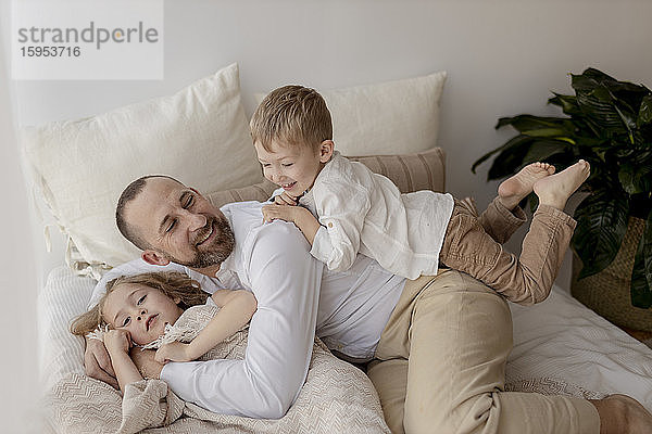 Familienporträt eines glücklichen Vaters und seiner beiden Kinder zu Hause