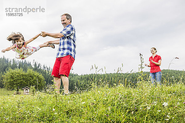 Vater spielt mit glücklicher Tochter auf einer Bergwiese  Achenkirch  Österreich